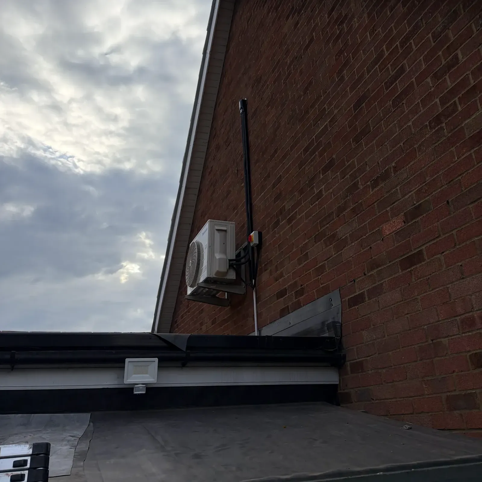 Outdoor air conditioning unit neatly fitted to the side of an Essex house